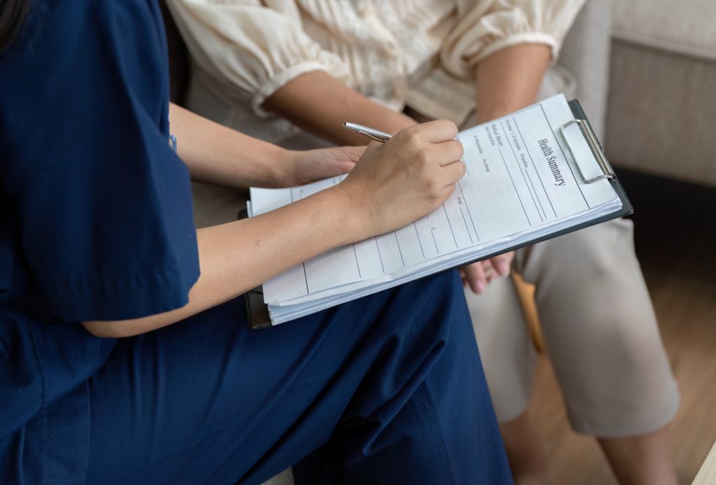 Therapist completing patient health assessment form during consultation