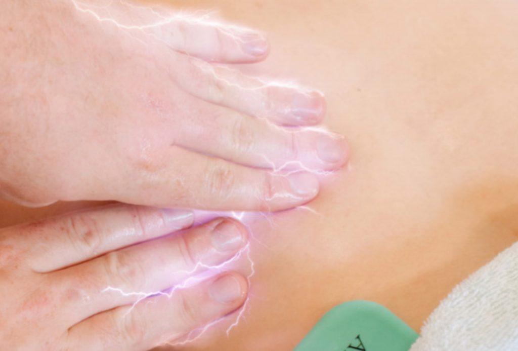 Therapist applying bioelectric meridian therapy to the abdominal area
